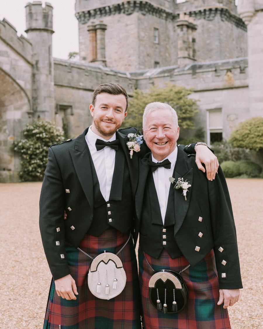 Steven Lindsay and his father George in Highland dress outside a Scottish castle
